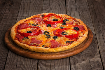 Delicious pizza served on wooden plate 