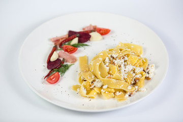 Tagliatelle pasta with ricotta and salad on white background