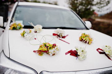 Close-up photo of a car bonnet decorated with flowers for wedding.