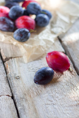 Plum fruits fresh white paper rustic wood background