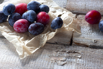 Fresh plum fruit on rustic white wood