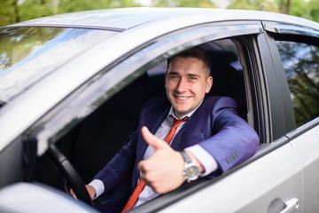 A successful business man smiling in the car.
