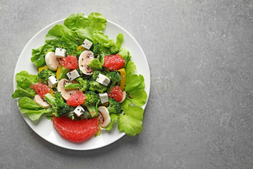 Plate with broccoli salad on grey background