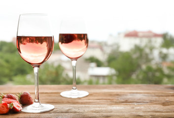 Glasses of delicious strawberry wine on blurred background