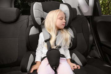 Fototapeta na wymiar Small girl sleeping in child safety seat