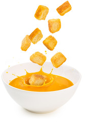 croutons falling into a soup bowl isolated on white - obrazy, fototapety, plakaty
