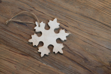 Christmas snowflake ornament on grunge wooden background.
