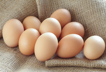 Pile of Brown fresh egg on brown fabric