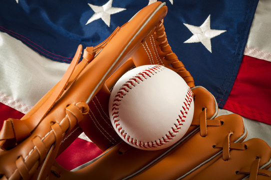 American Sports And College Athletics Concept With The USA Flag In The Background And Macro On A Vintage Baseball Glove Holding A Ball With Copy Space