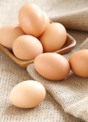 Pile of Brown fresh egg on brown fabric