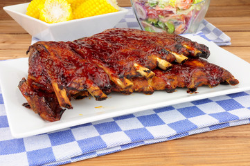 Barbecued pork ribs meal with sweetcorn and fresh salad