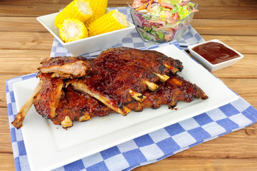 Barbecued pork ribs meal with sweetcorn and fresh salad
