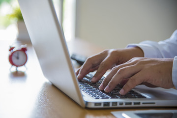 Man's hands typing on laptop keyboard