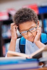 schoolboy reading book in library