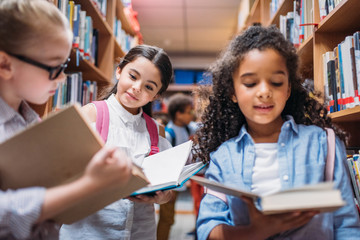 schoolgirls looking for books in library