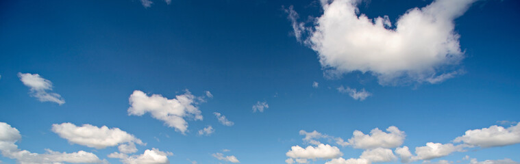Obraz premium Panorama of the blue sky with scattered white clouds
