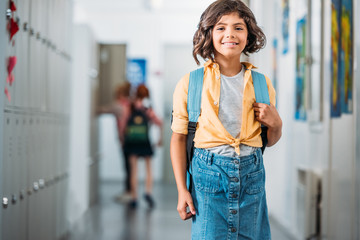 schoolgirl with backpack in school corridor
