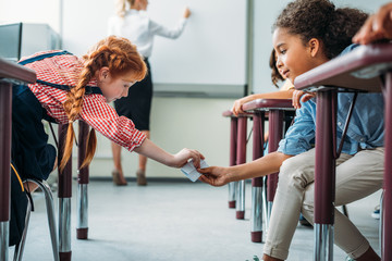 schoolgirls passing message in class