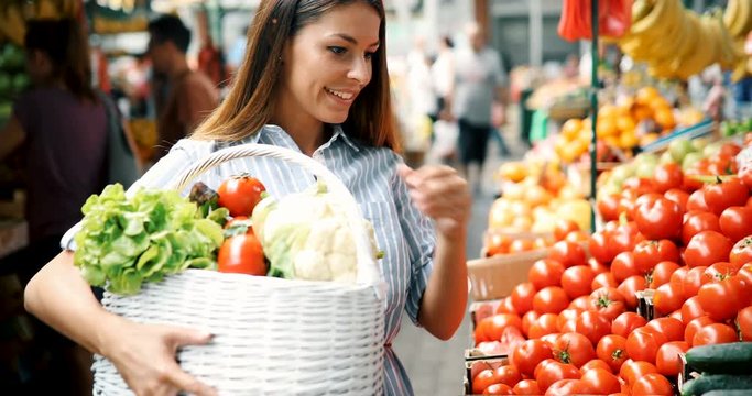 Picture of woman at marketplace buying vegetables