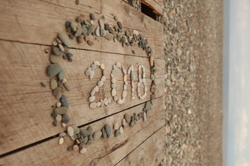 Inscription 2018 with stones on a wooden background