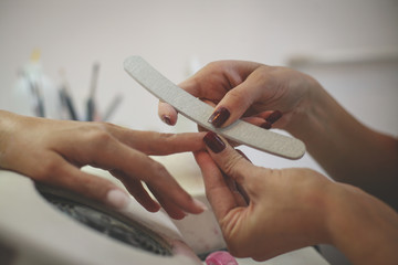 Obraz premium Close-up of female hands being manicured at a beauty salon.