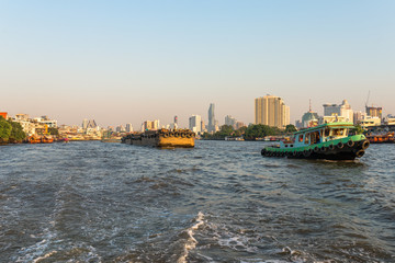 Fototapeta na wymiar Pusher with barges on the Chao Phraya river in Bangkok. The river meanders through the city in southward direction, emptying into the Gulf of Thailand approx 25 kilometres south of the city centre