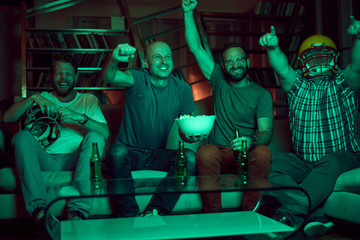 Four men watching american football game on television
