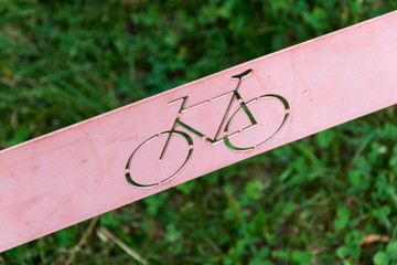bicycle sign on metal plate with grass in background