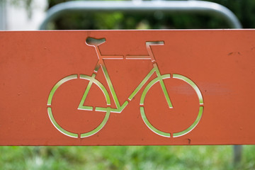 bicycle sign on metal plate with grass in background