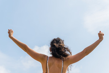 woman with hands up  with sky in the background