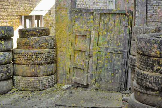 Abandoned paintball playground with barricades made of old tires with paint marks after fights
