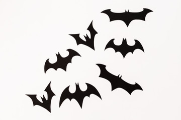 Handmade black paper bats on white background. Flat lay, top view. Halloween holiday concept.