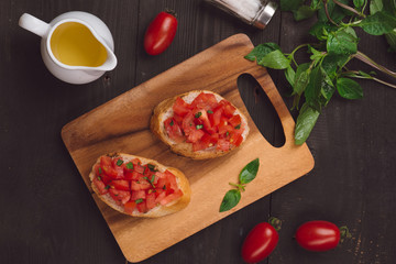 Simple italian appetizing bruschetta with tomato, on wooden table