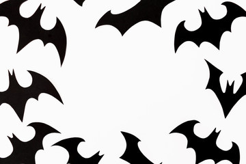 Halloween holiday frame concept. Handmade black paper bats on white background. Flat lay, top view.