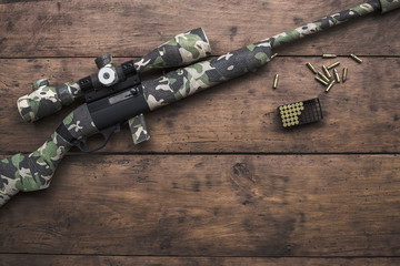 Small caliber 22 long rifle with an optical sight and cartridges in camouflage tape
