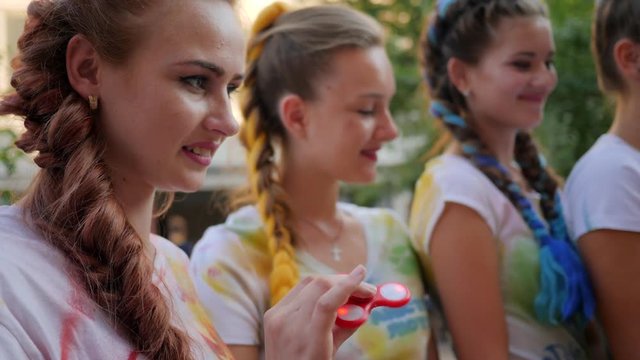 toy for stress relief, spinner spinning in slow motion, spin in hand girl outdoors, close-up arm showing trick with spinners, youth movement playing with modern popular hand toy