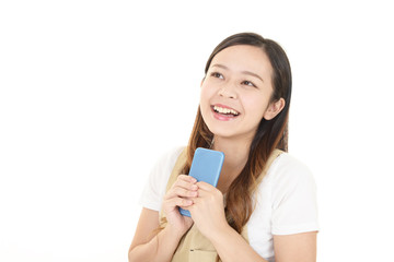 Fototapeta premium スマートフォンを持つ笑顔の女性