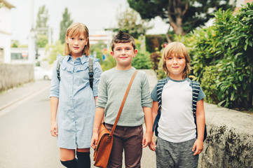 Cute kids with backpacks walking back to school