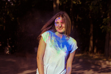 Happy young model with long hair covered with colorful Gulal powder