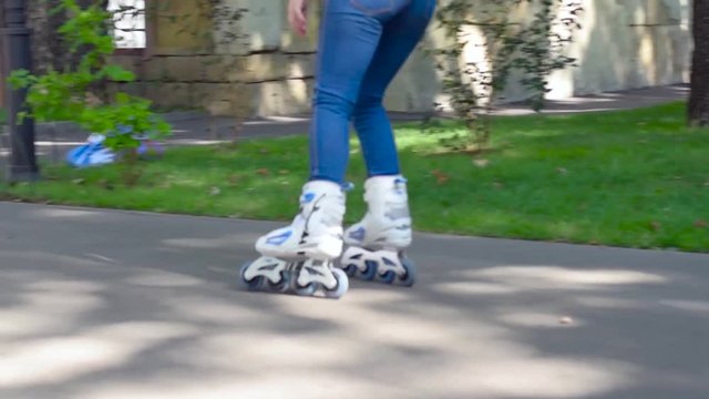 Girl rollerblading in the city park. Caucasian woman in outdoor activities.