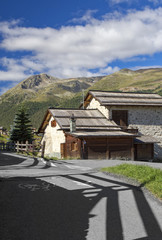Brown house next to paved road with grass
