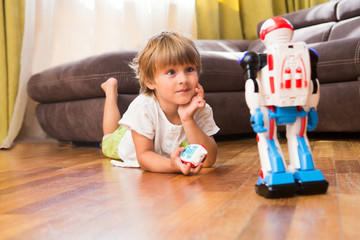 Little boy playing with robot toy at home
