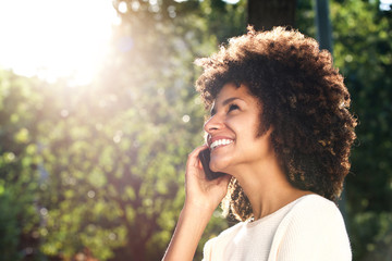 Fototapeta premium Close up smiling woman talking on mobile phone in park