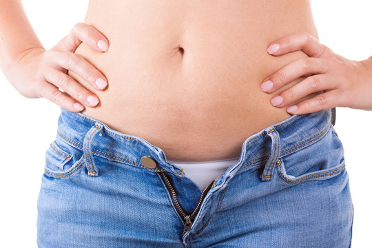 Diet Concept. Women Hands Unable to Close the Jeans due to Gaining Fat on Hips