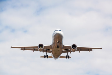 airplane flying overhead - landing / takeoff - blue sky with clouds