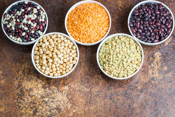 Different kinds of  lagumes- beans, lentils, and chickpeas on old rusty background.