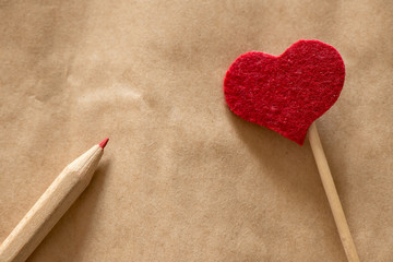 love message - red heart and pencil on paper beige background - text space