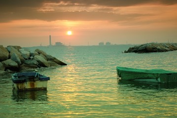 Floating boat in the evening sea