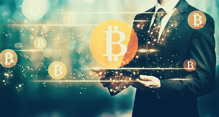 Bitcoins with man holding a tablet computer