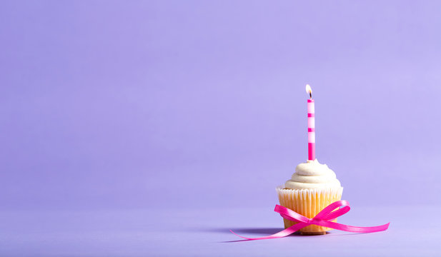 Cupcake with candle celebration theme on a purple background